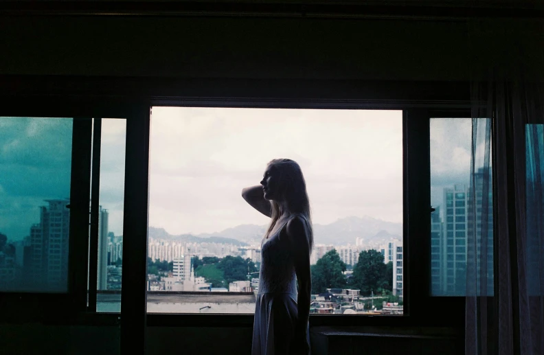 a woman is looking out a window at the view