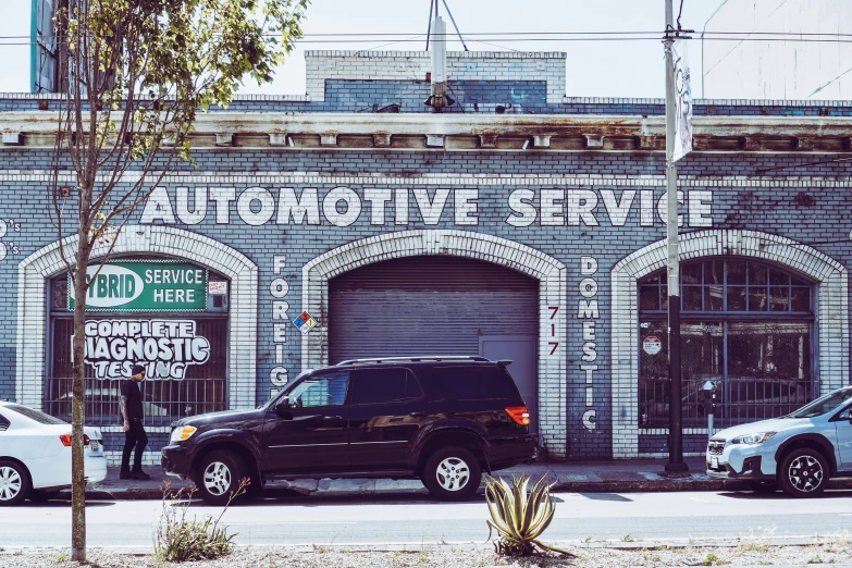 a couple of cars are parked outside of the auto repair shop