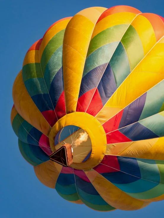 a large rainbow colored  air balloon flying in the sky