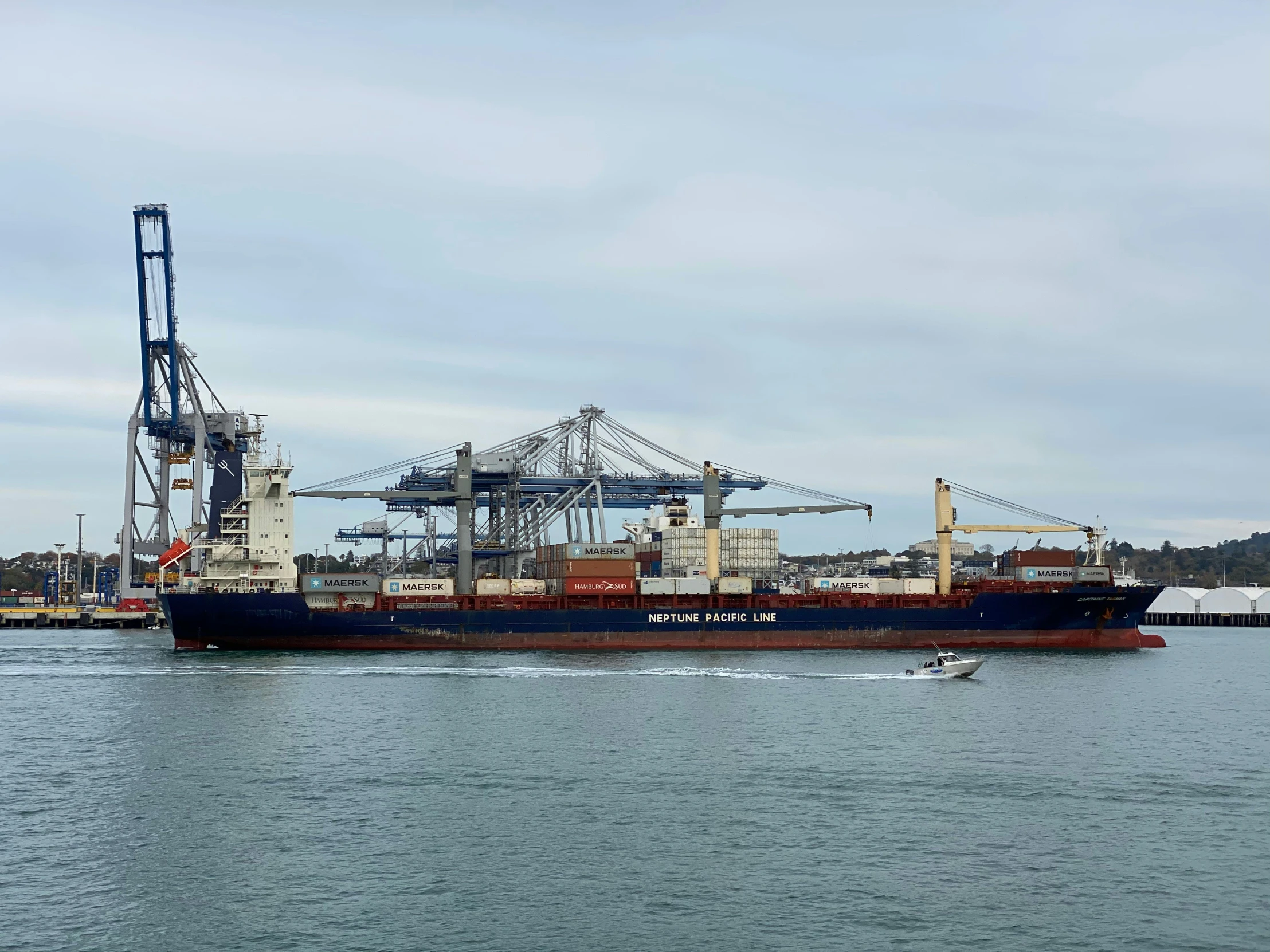 a large ship docked in a harbor with cranes