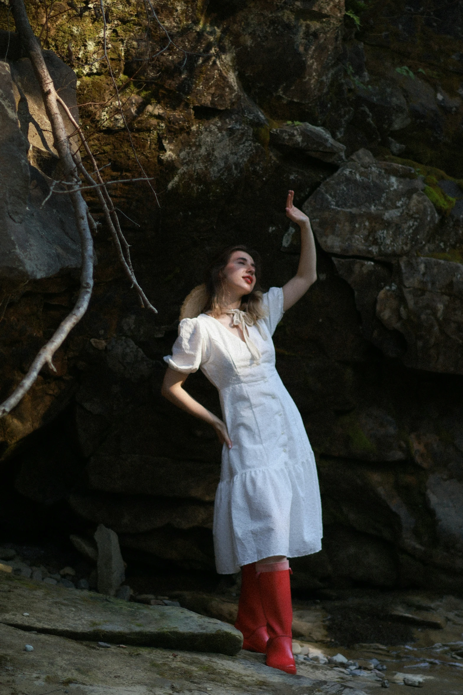 there is a woman that is standing by some rocks