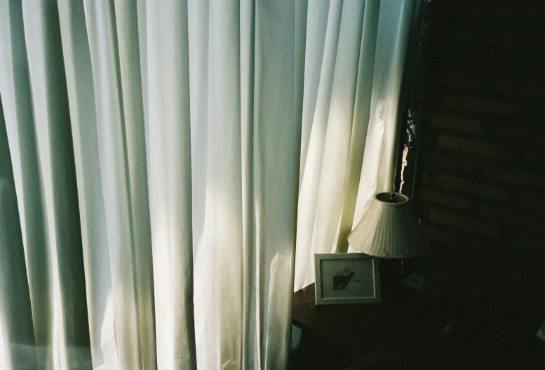 close up of window curtains in room with sun coming through