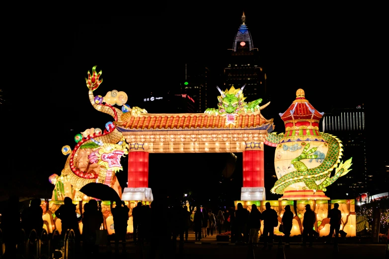 people gathered at night in front of a chinese arch