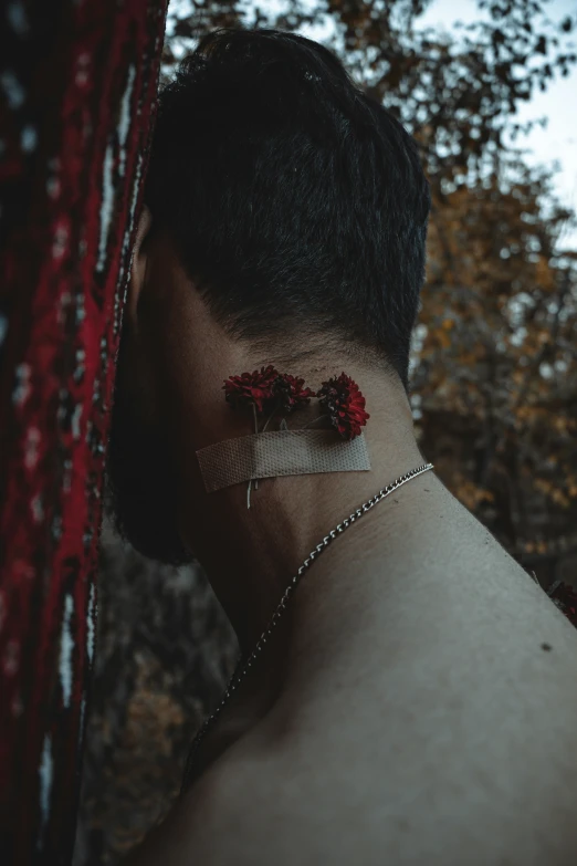 a close up view of a man with flowers on his neck