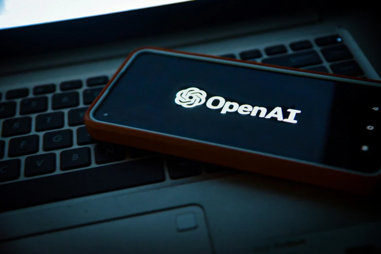 openall logo displayed on a smartphone next to an open laptop