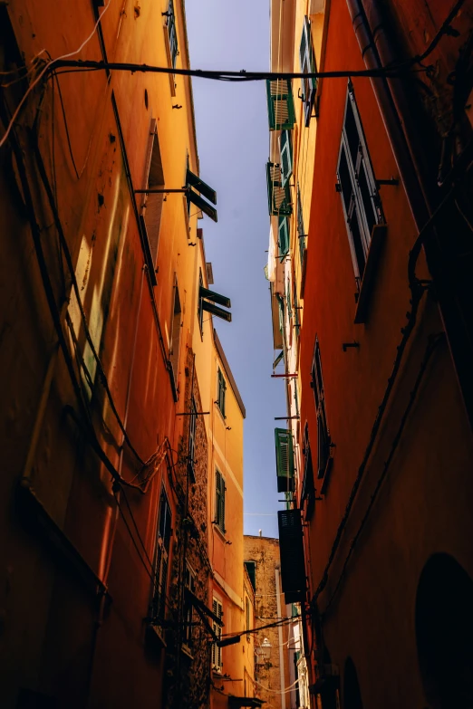 narrow street leading to tall buildings with windows and street lights