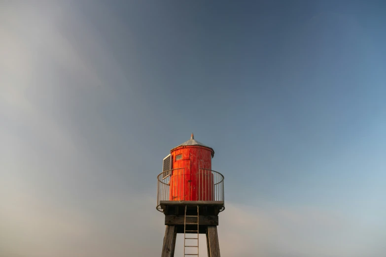 a small light house on the water with a balcony