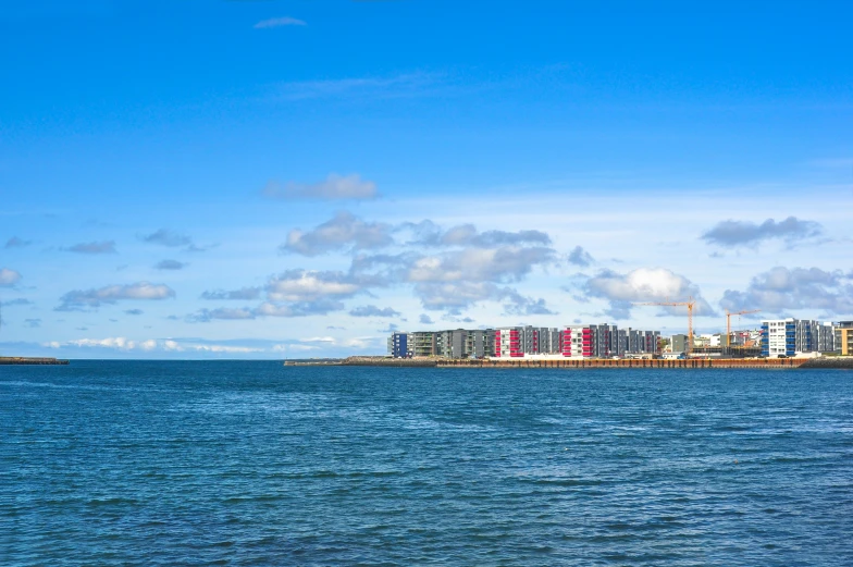 a large body of water sitting next to a long building on a city