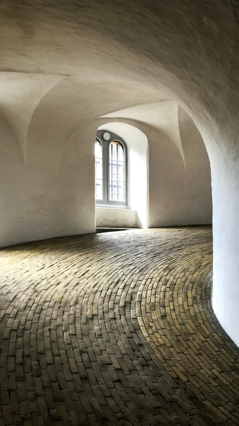 a room with brick floor and arched doorway