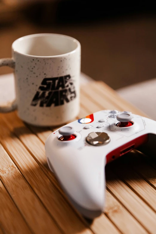a coffee mug and gaming controller are sitting on a table