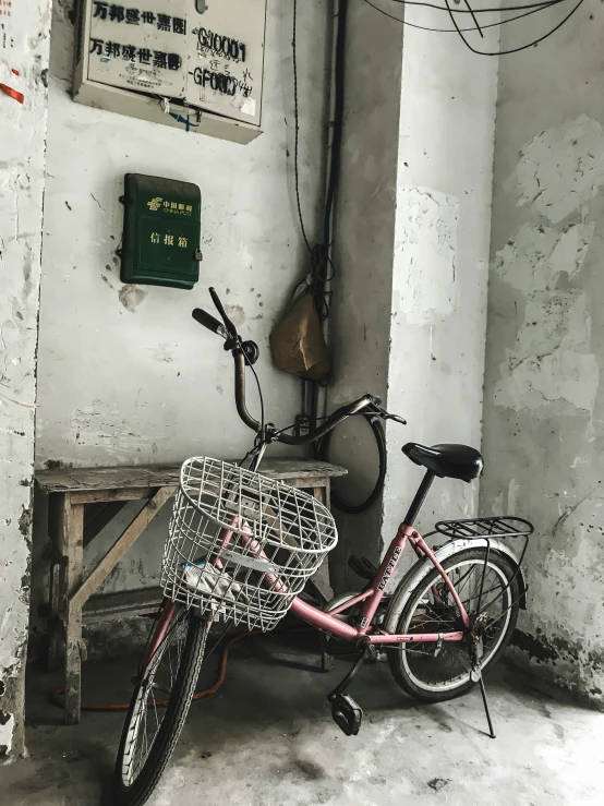 a pink bike is  up to the wall