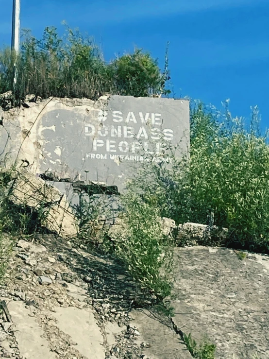 an old sign on top of a rock formation