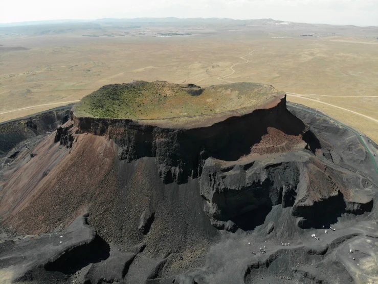 a volcano is shown from the air, surrounded by land and mountains