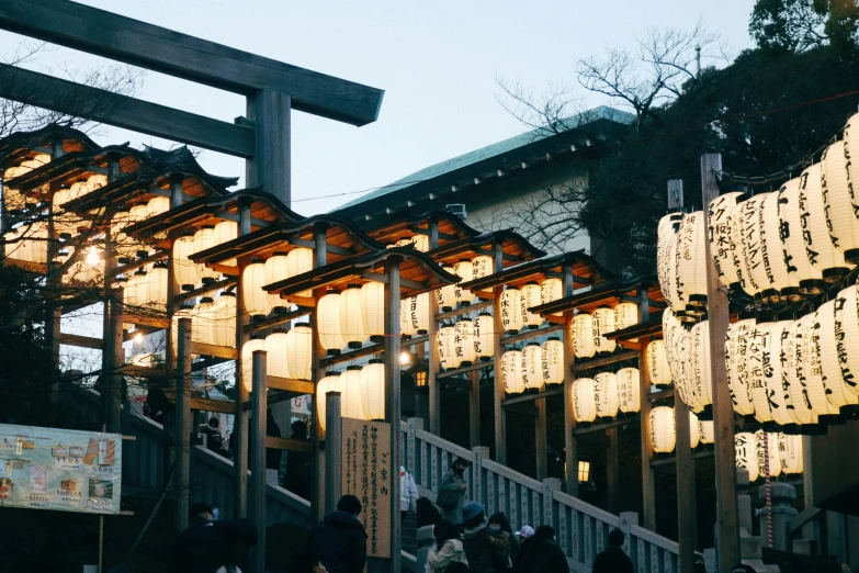 a lantern with asian writing on it hanging over the top of a walkway