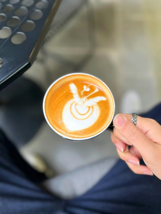 a person holding onto a cup with coffee