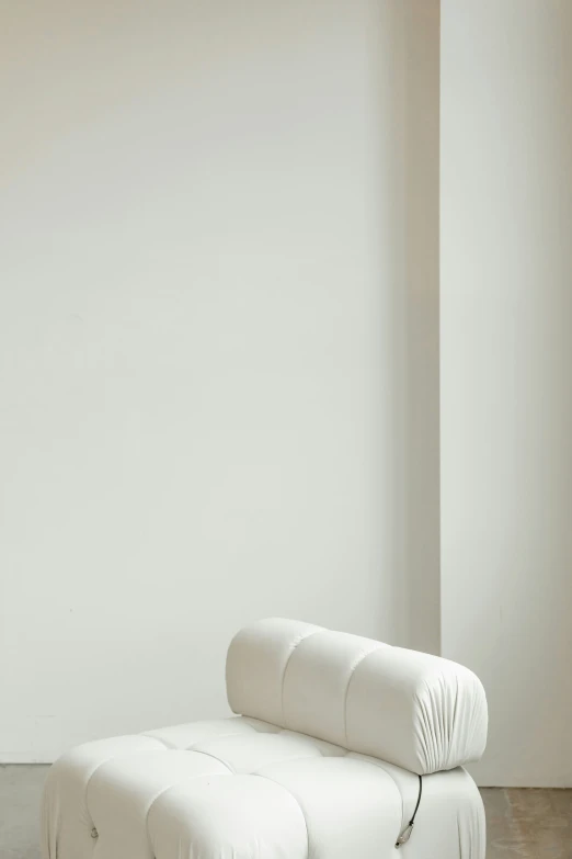 a white chair in front of a white wall