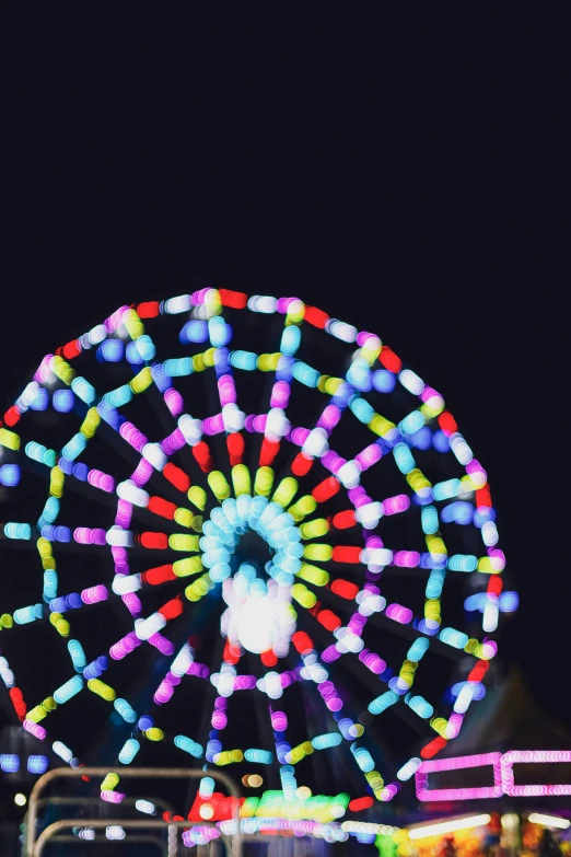 a ferris wheel that is lit up by brightly colored lights