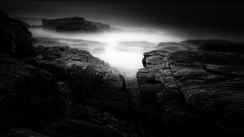 black and white image of lightening over rocky coastline