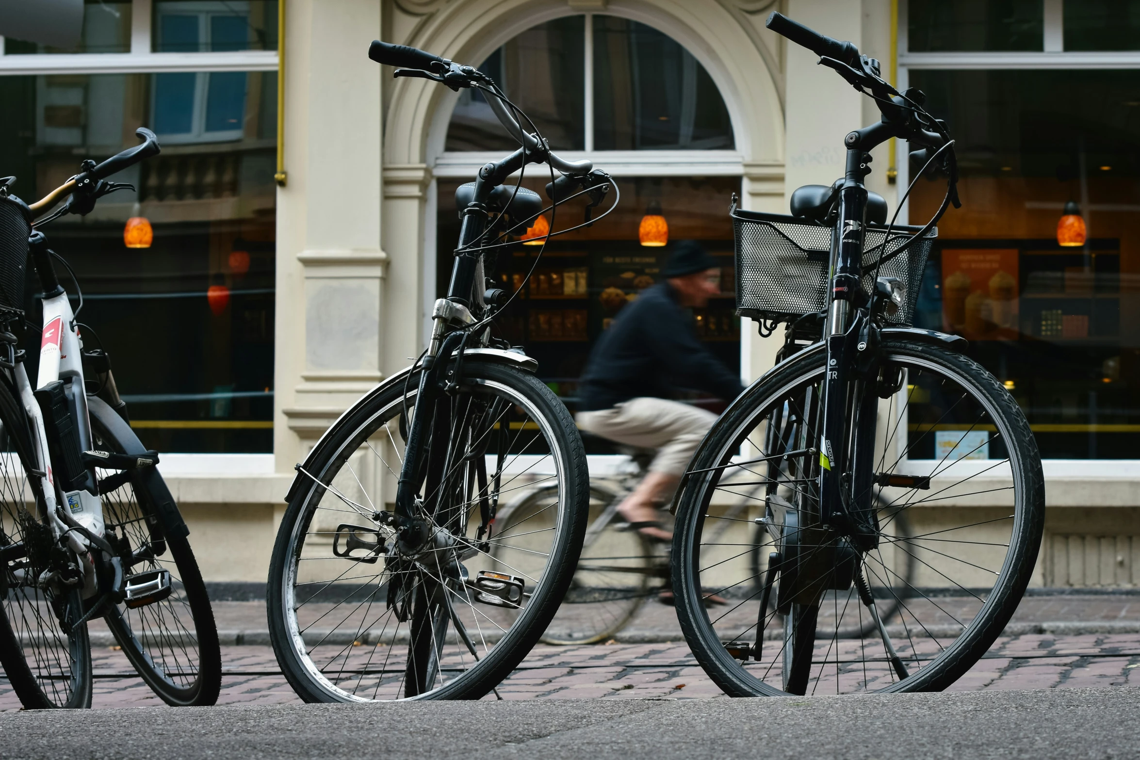 three bicycles are parked on the side of a street