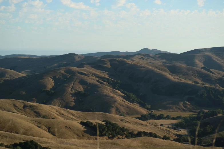 a hilly area with hills and trees in the distance