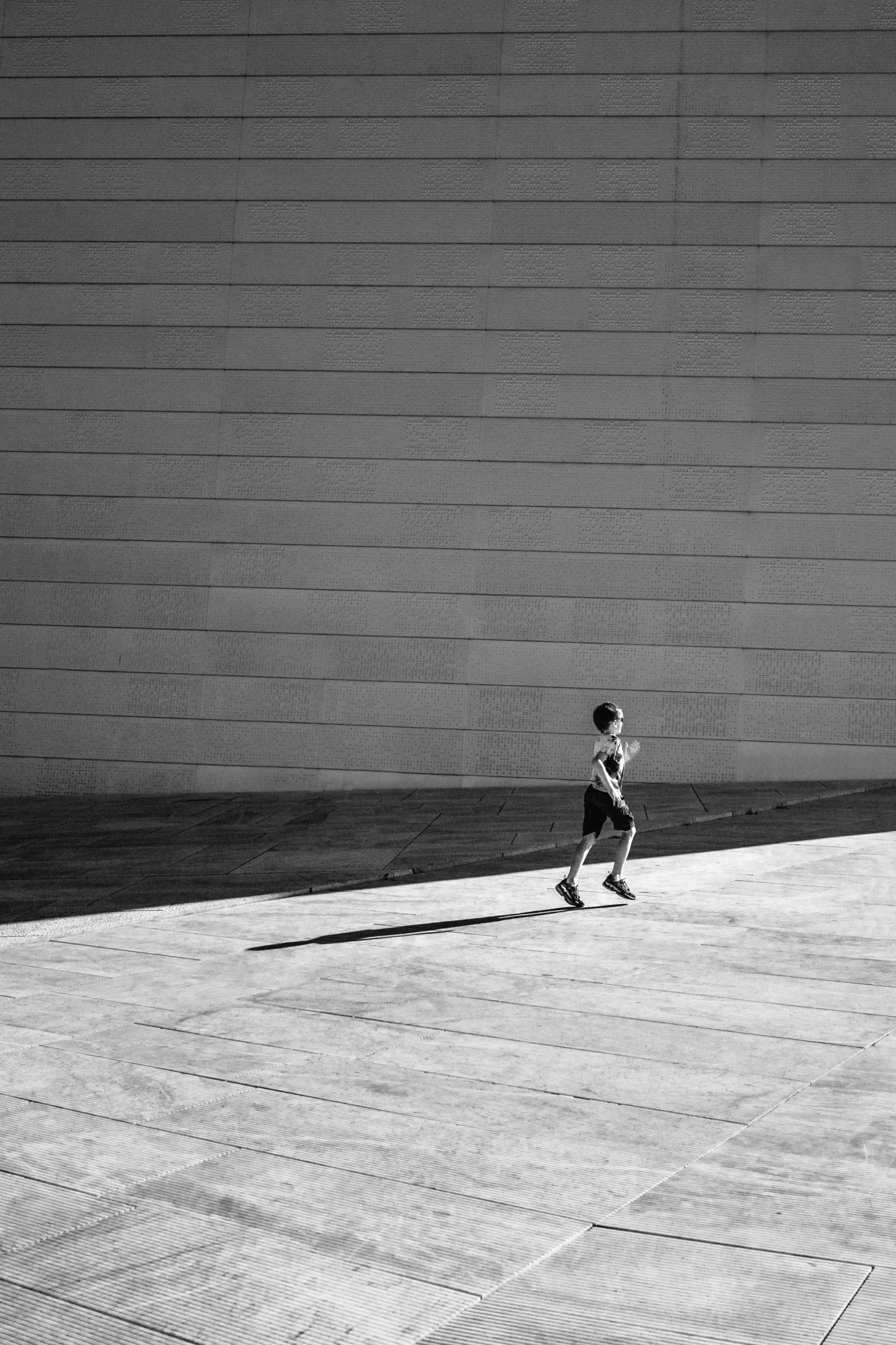 a black and white po of two people walking on a sidewalk