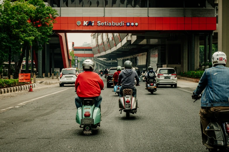 three motorcycles with riders in traffic on a city street