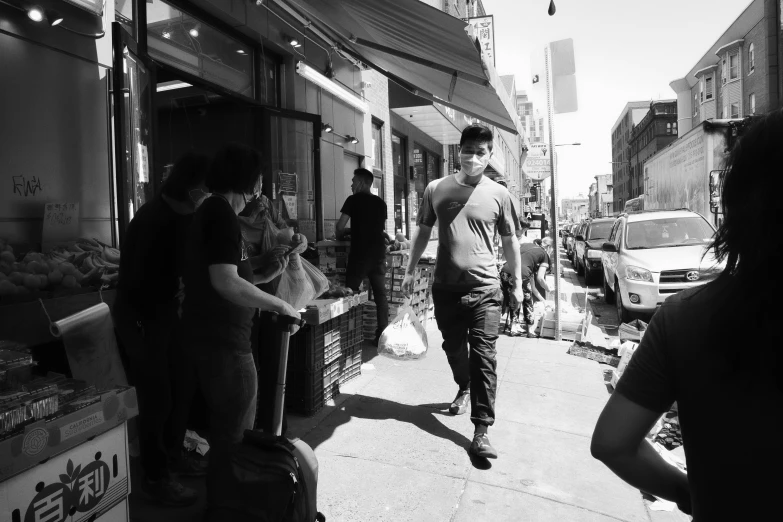 a group of people walking down a sidewalk near stores