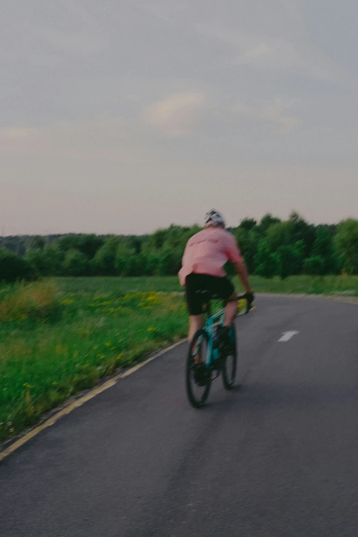 a person riding a bike down the middle of a country road