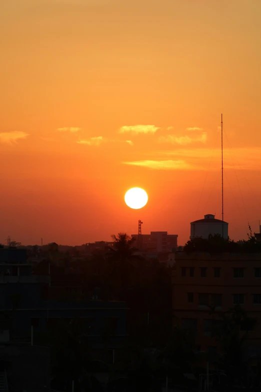 the setting sun is shown in the background, overlooking houses