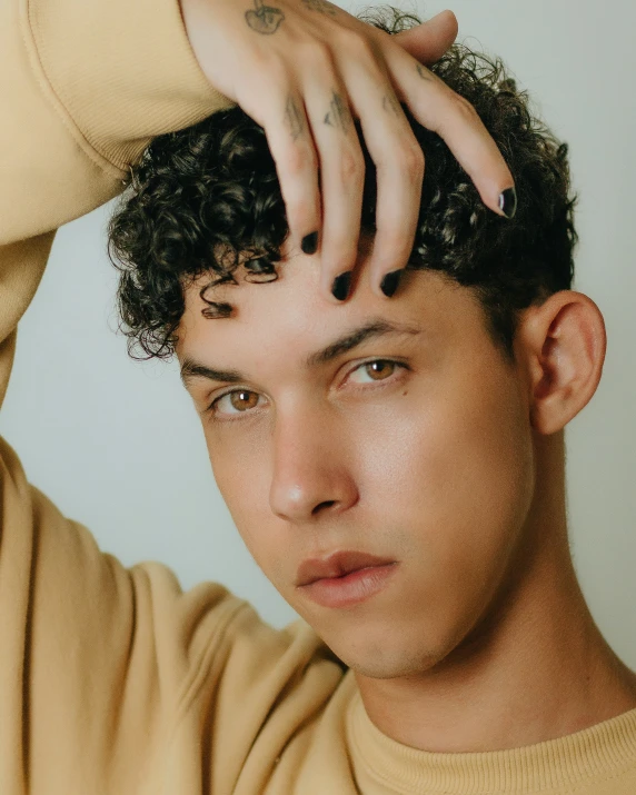 a young man scratching his head with his hands