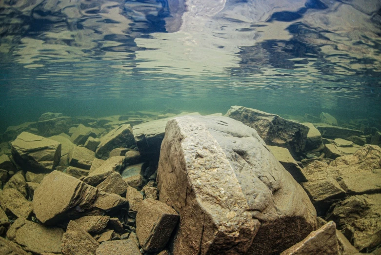 rocks are visible beneath the water on this beach