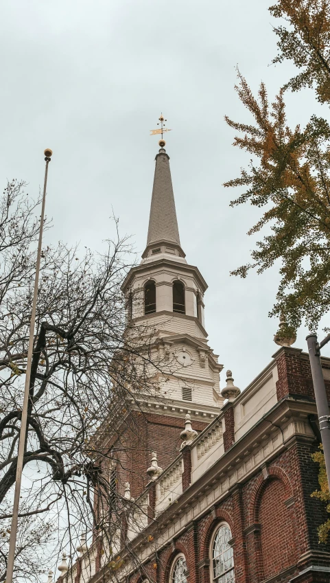 an old building features steeple with weather vane