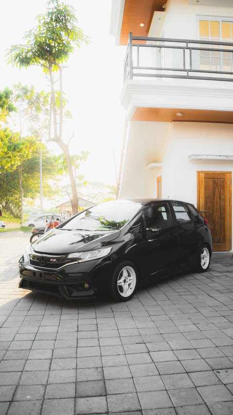 a black car is parked next to the white building