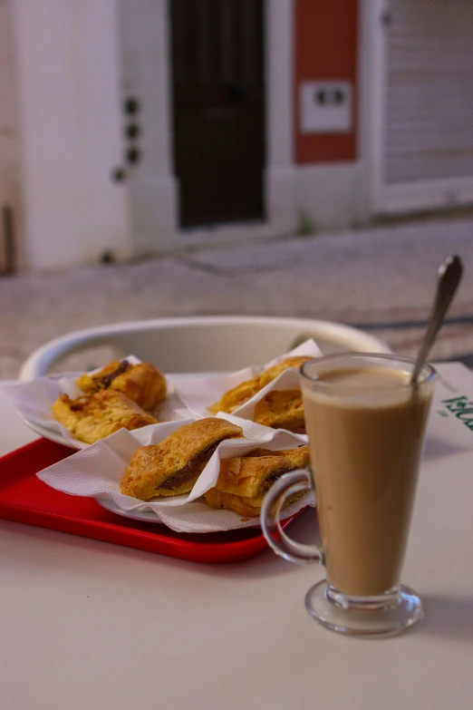 snacks, coffee, and a drink are sitting on a tray on a table