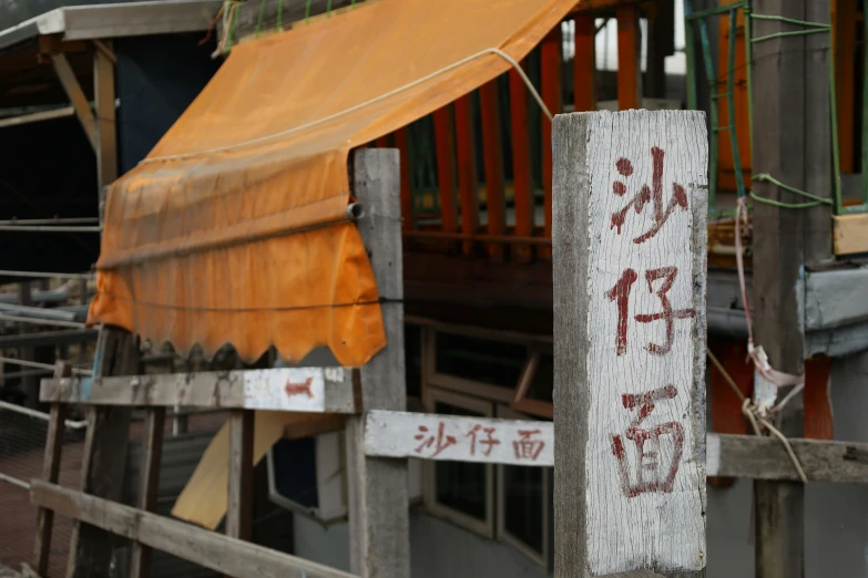 a rusted wooden post and a sign in front of a building