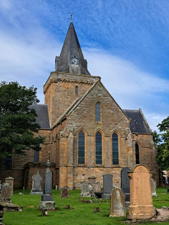 an old church with a clock tower and headstones