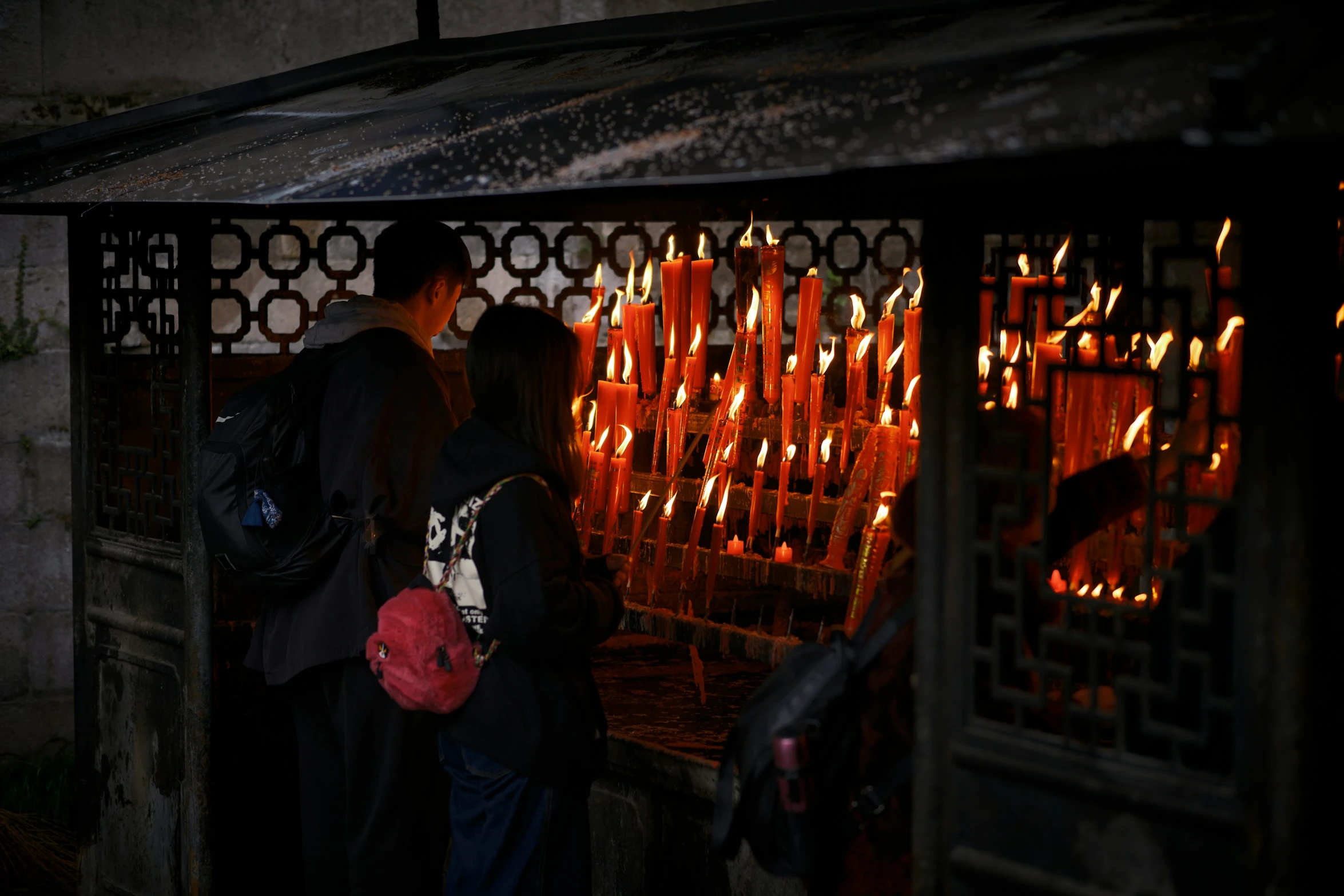 a man is standing by some lit candles