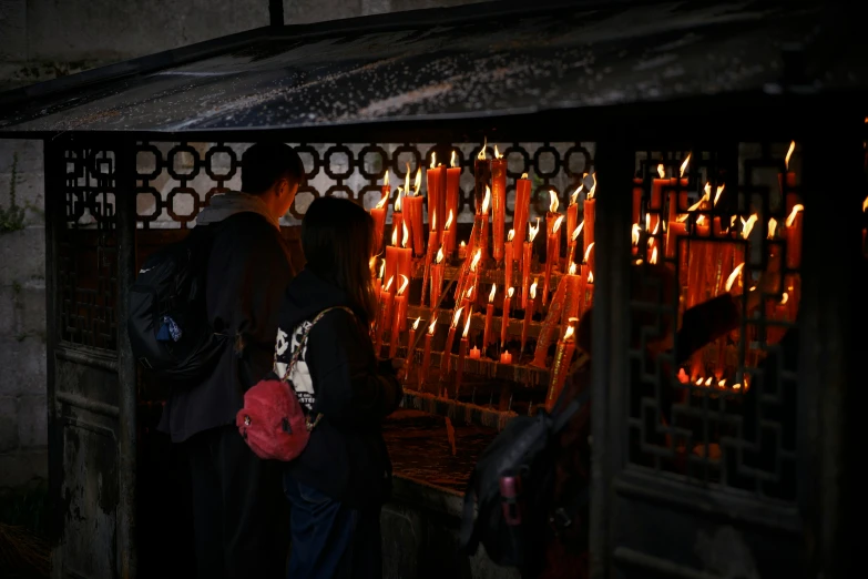 a man is standing by some lit candles