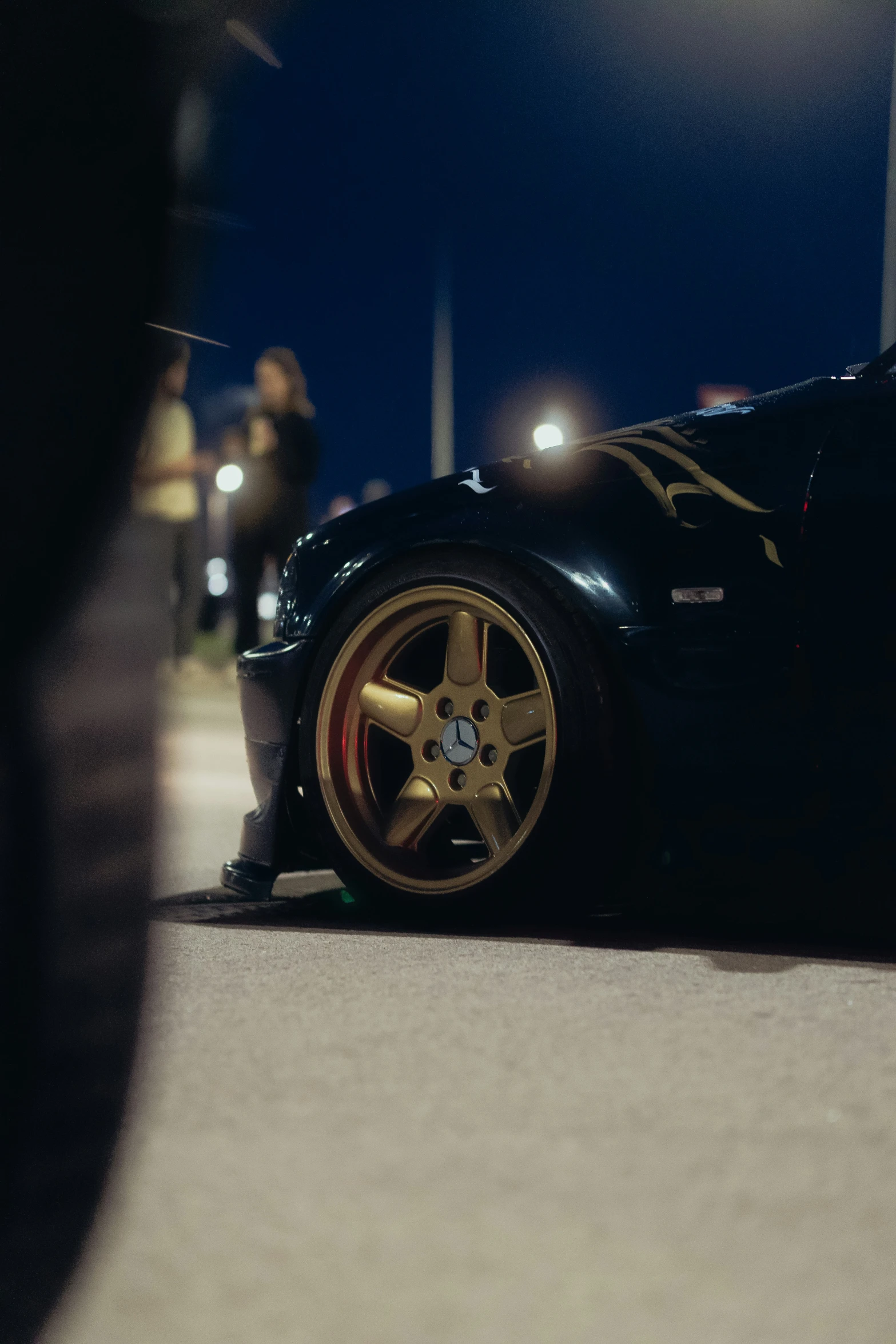 a black sports car parked in a parking lot at night