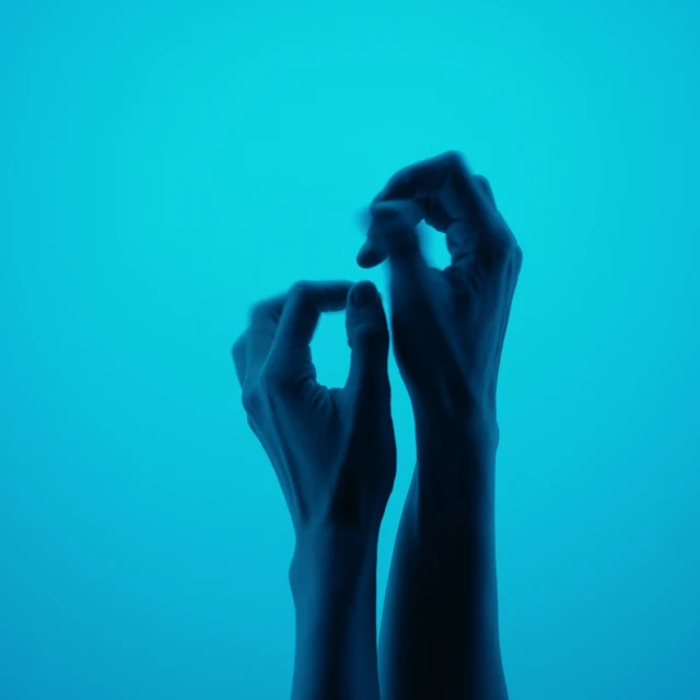 a person holding the fingers on a wall with their arms above water