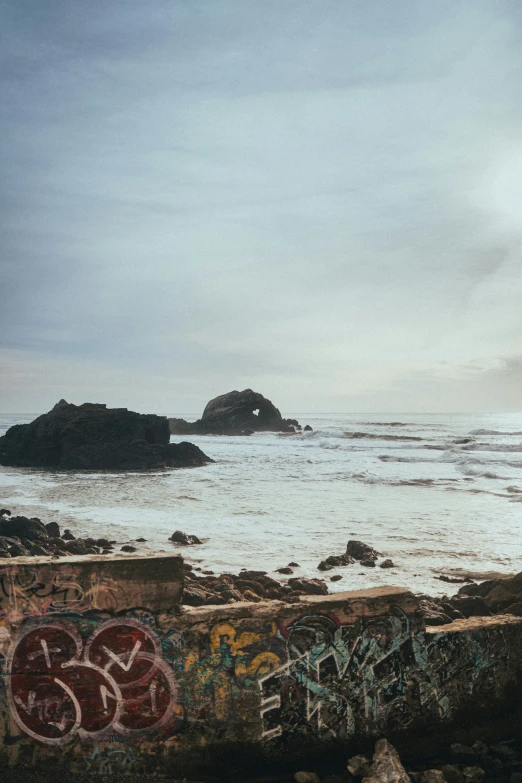 some sea rocks and graffiti on the beach