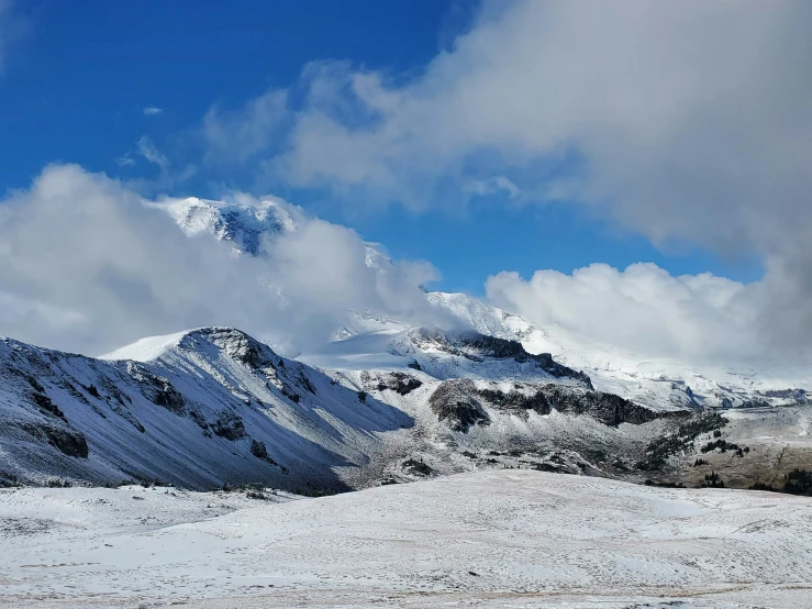 mountains under cloudy skies with a blue sky