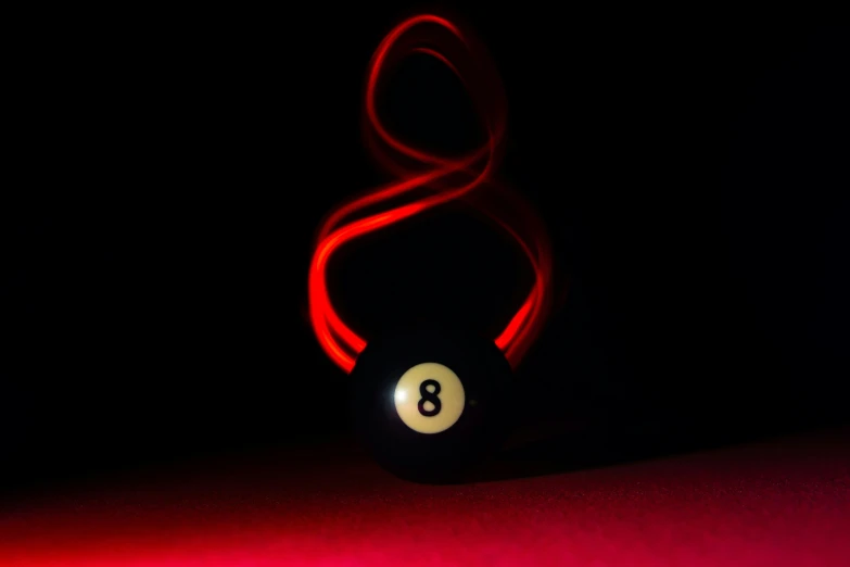 a eight - ball sits in a pool ball holder that is illuminated by the bright light