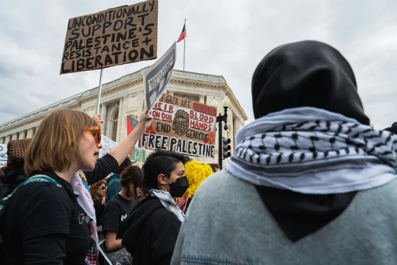 a woman holding a protest sign on a city street