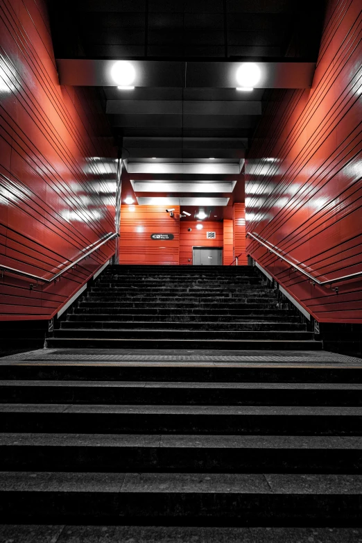 a stair case lined with red walls and steps