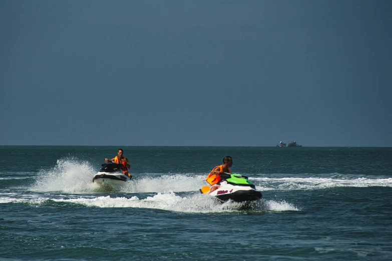 two people are on jetskis in the water