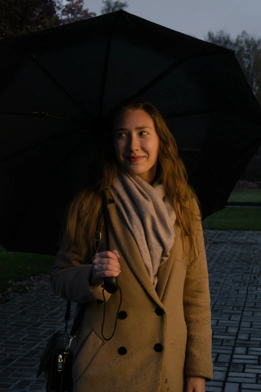 a beautiful young lady holding an umbrella on the street