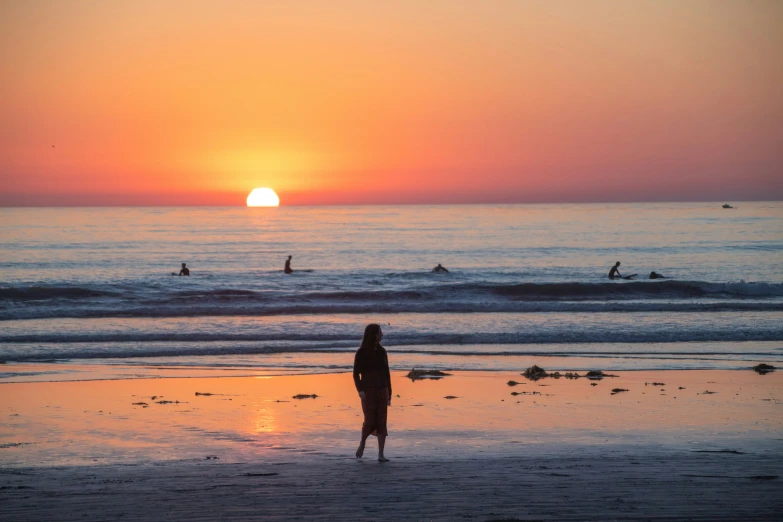 the surfers are swimming in to the water as the sun rises