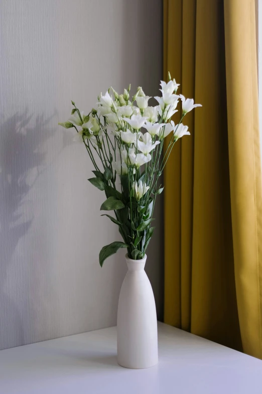 vase with flowers on table near window