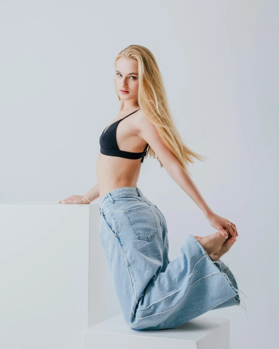 a woman with blonde hair sitting on a white block